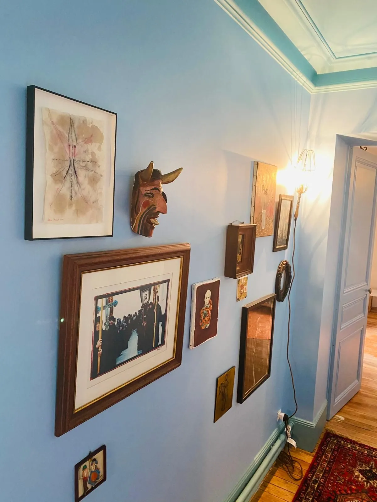 Mur bleu orné de cadres et de tableaux dans le couloir