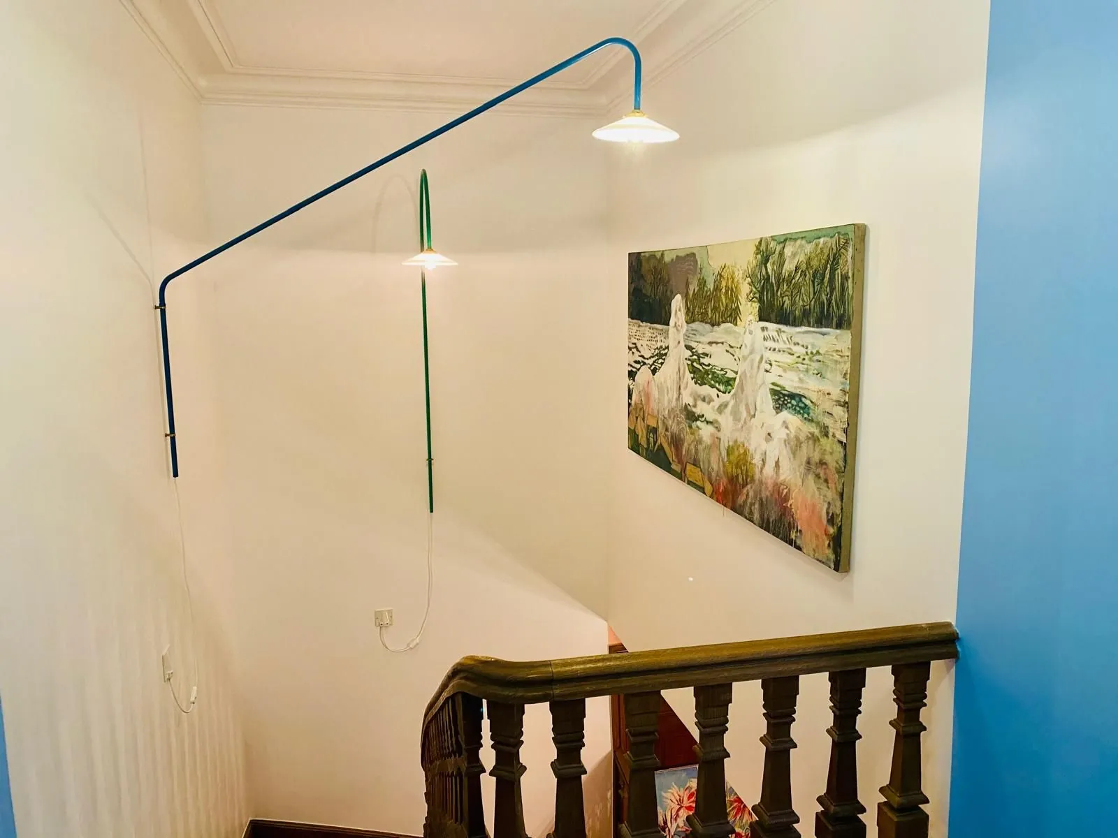 Cage d'escalier peinte en bleu avec applique murale
