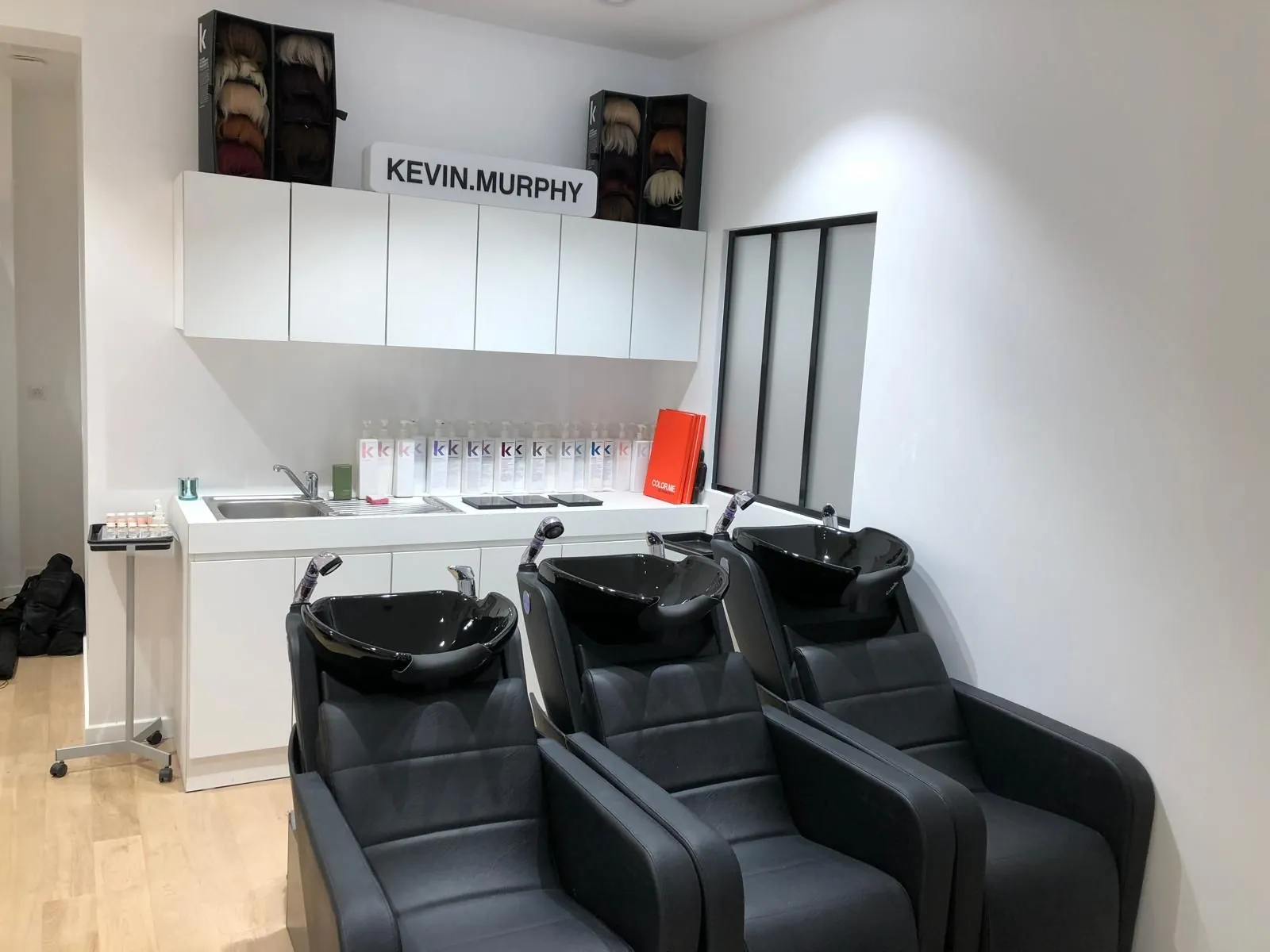 Espace shampoing avec trois bacs noirs et meuble blanc
