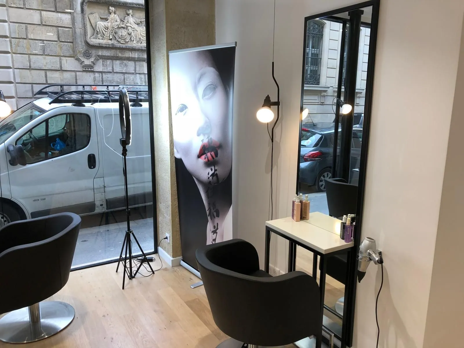 Poste de coiffage avec miroir, fauteuil noir et affiche