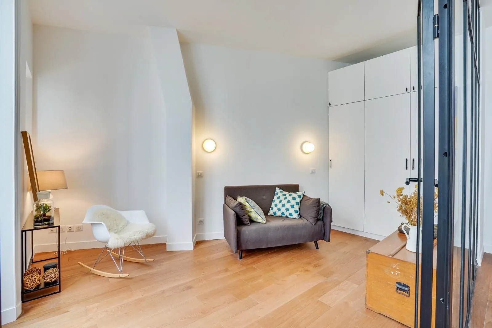Coin salon avec fauteuil et grandes armoires blanches