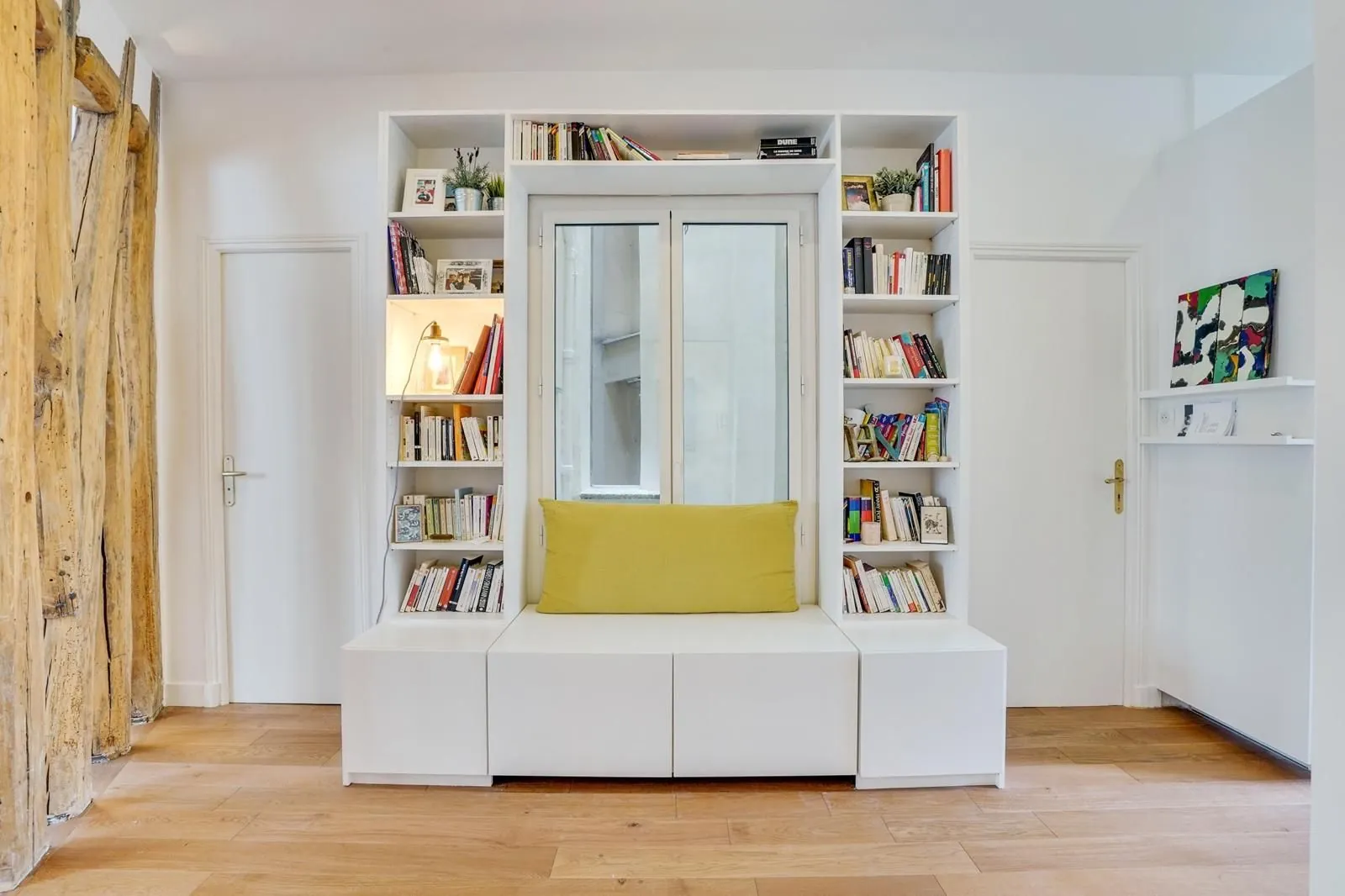Bibliothèque sur mesure avec banquette jaune et fenêtre