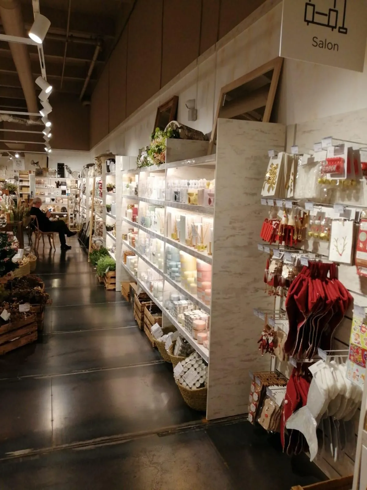 Allée du magasin avec rayonnages blancs et accessoires