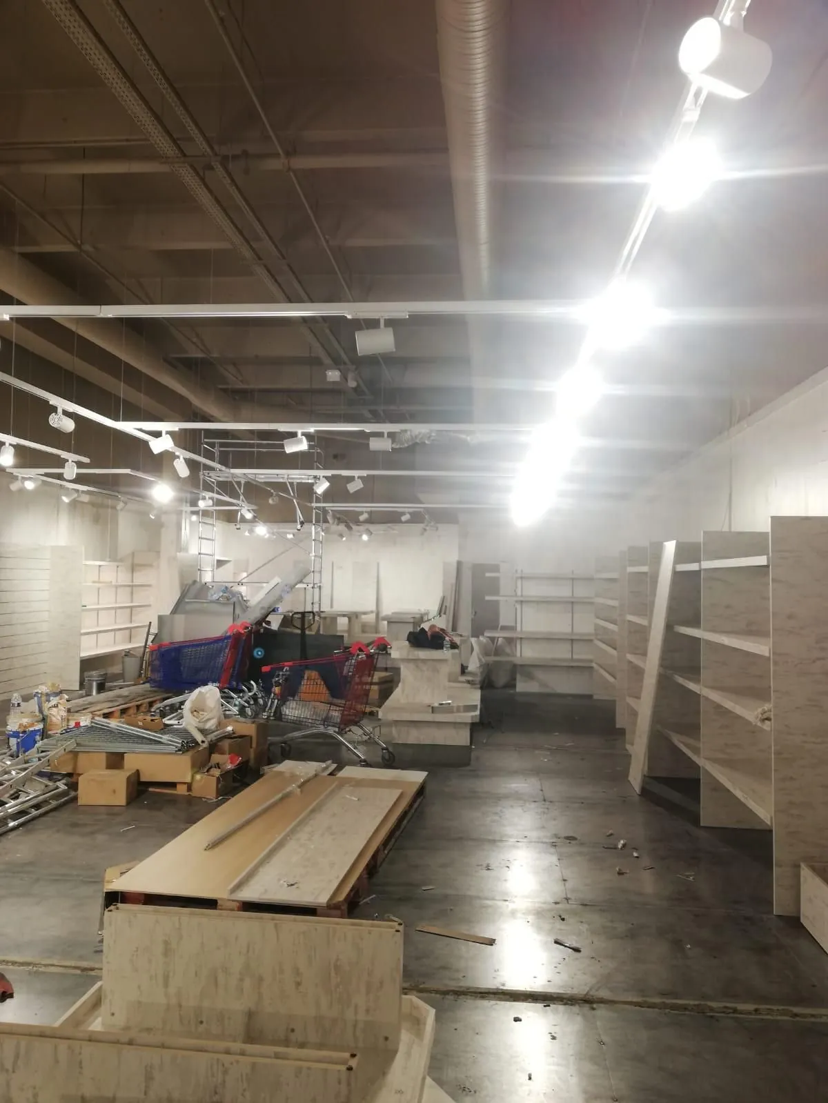 Magasin en cours d'aménagement, rayonnages et matériaux au sol