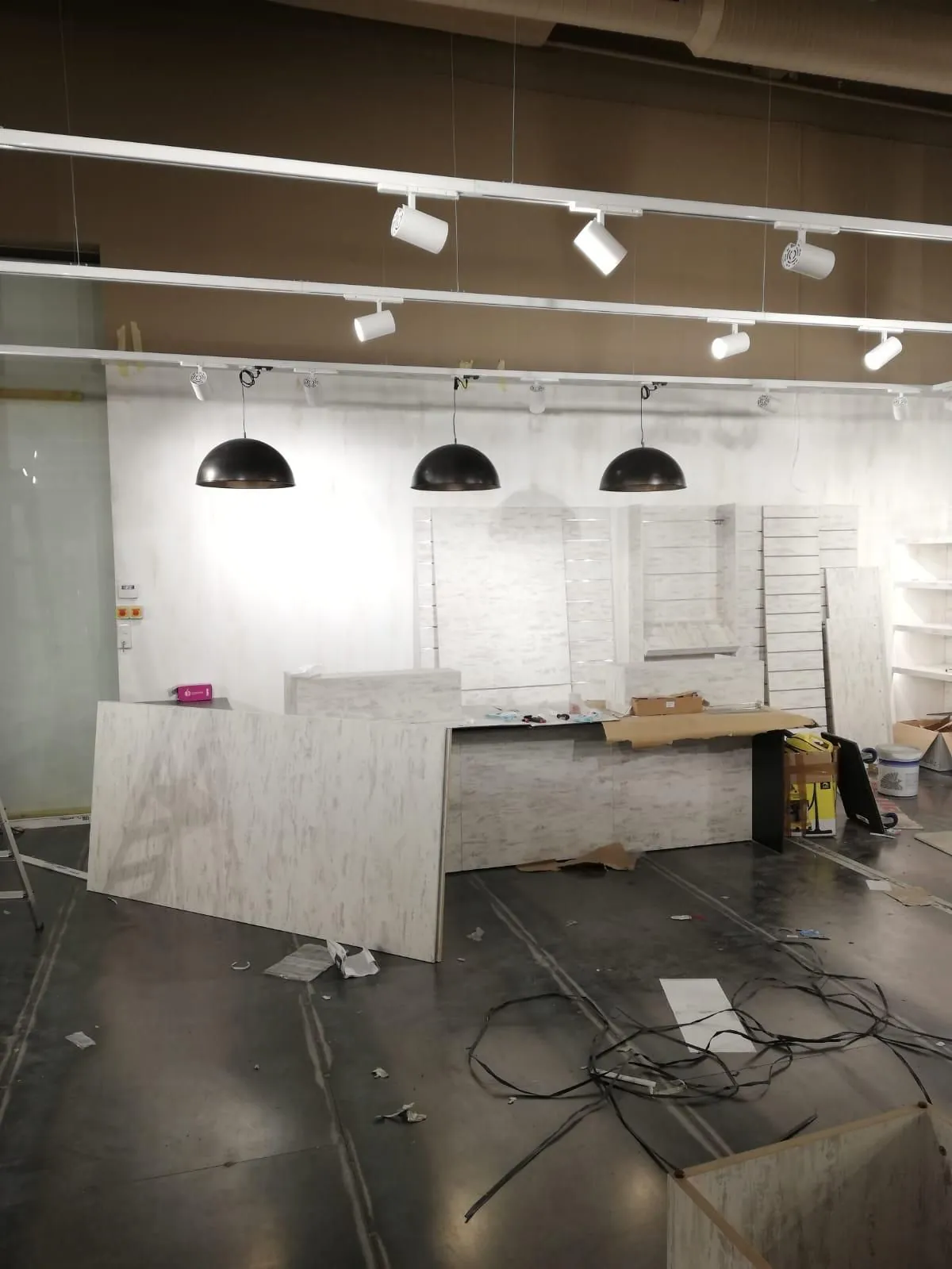 Espace du magasin en cours d'installation, avec suspensions noires